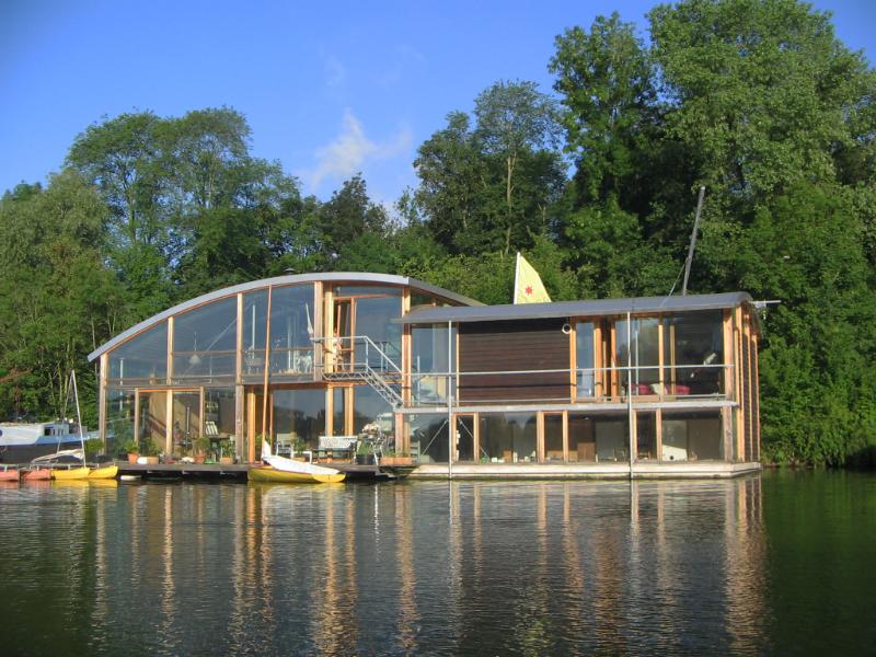 houseboat-002.jpg - Een betonnen bak met een opbouw.  De opbouw bestaat uit een stalen frame ingevuld met hout en glas en een gebogen profielplaten dak.