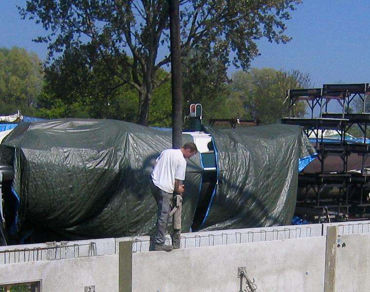 woodenhouse-028.jpg - De holle wand wordt afgestort. De eerste vulling (stort) bestaat uit een fijn soort beton dat onder in alle hoeken kruipt en luchtinsluiting voorkomt en zodoende een waterdichte hechting maakt.