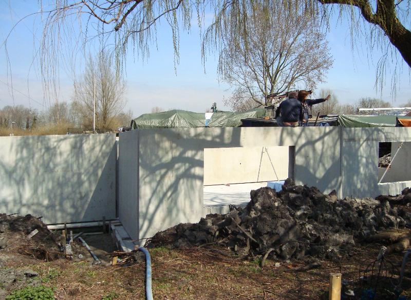 woodenhouse-022.jpg - Le murs creux préfabriqués sont posés. On aperçoit le bord extérieur du sol. Le fer à béton se trouve maintenant entre les côtés intérieurs du mur